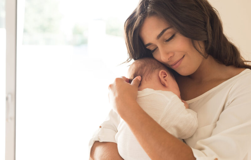 Pretty,Woman,Holding,A,Newborn,Baby,In,Her,Arms
