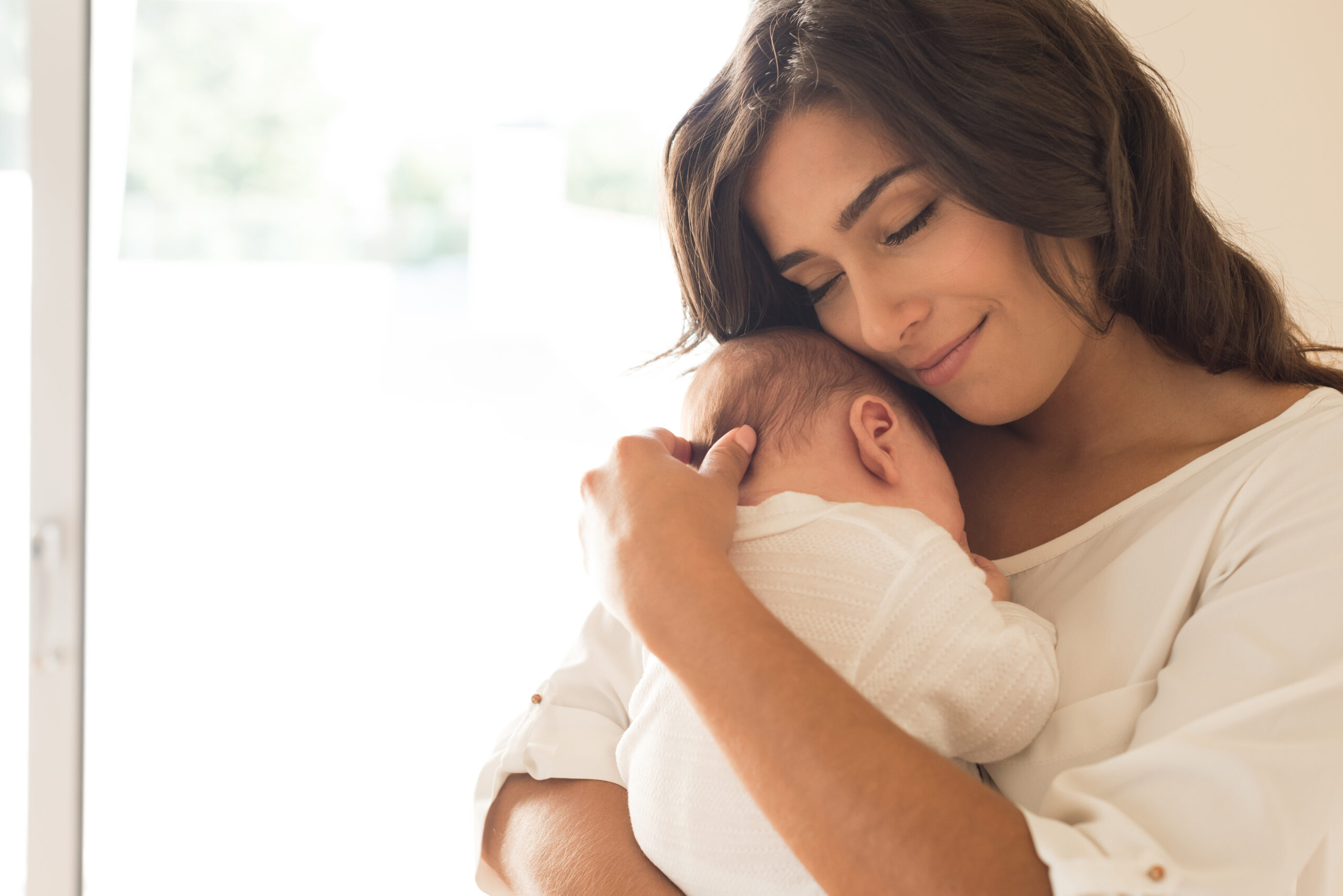 Pretty,Woman,Holding,A,Newborn,Baby,In,Her,Arms