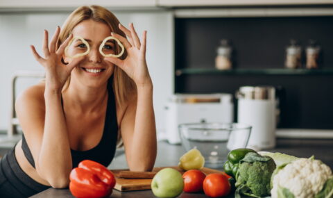 Young sporty woman with pepper at the kitchen